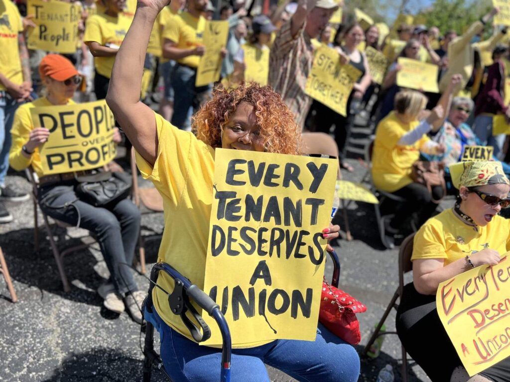 Person holding sign that says "Every Tenant Deserves a Union"