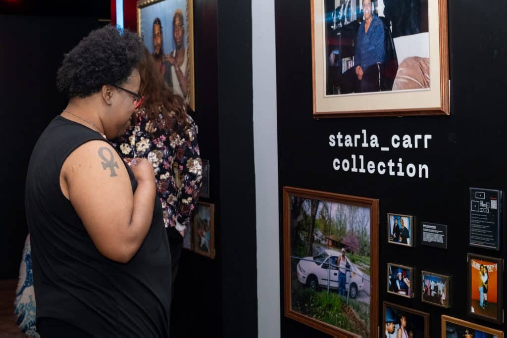 Black woman views gallery wall of vintage frames