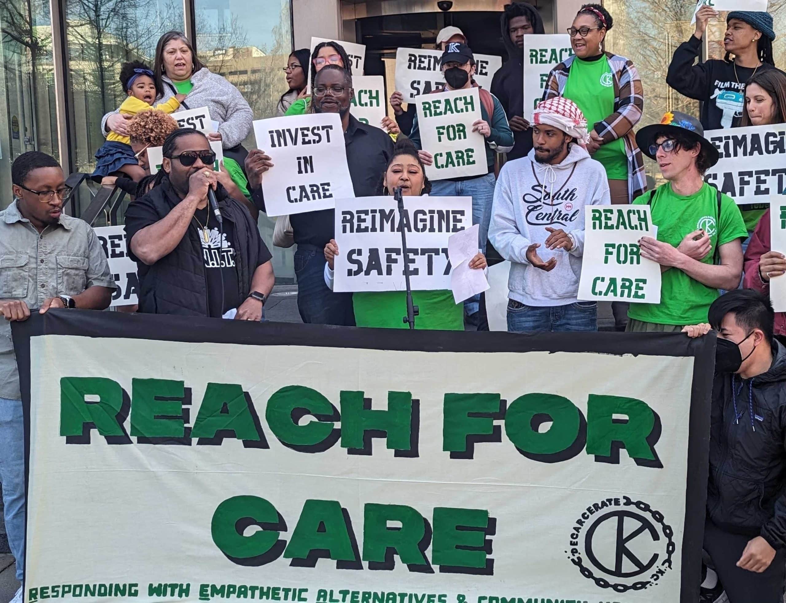 Members of Decarcerate KC are standing on steps and holding signs